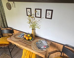 Gezellige eetruimte in de glamping lodge van Huisje in Sint Anthonis, Noordoost Brabant, met natuurlijke decoratie.