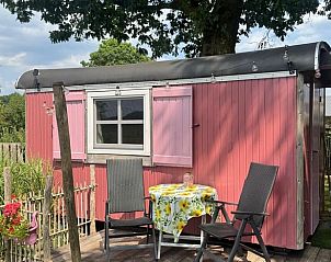 Charmant roze vakantiehuis met terras bij Vakantiehuis in Sint Anthonis, Noordoost Brabant, omgeven door groene natuur.