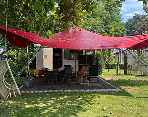 Ruim terras met schaduwdoek bij Vakantiehuis in Sint Anthonis, Noordoost Brabant, ideaal voor buitenactiviteiten.