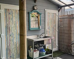 Praktische wasruimte bij Vakantiehuis in Sint Anthonis, Noordoost Brabant, met kleurrijke deuren en moderne voorzieningen.