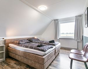 Comfortabele slaapkamer in Bij de Buren vakantiehuis Oploo met uitzicht op natuur.