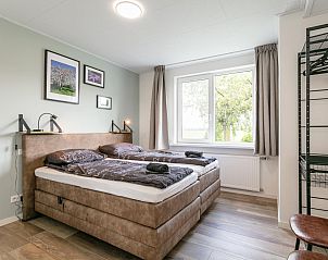 Ruime slaapkamer in Bij de Buren vakantiehuis Oploo met grote ramen.