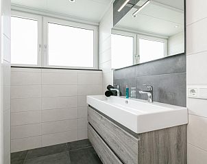 Moderne badkamer met dubbele wastafel in Bij de Buren vakantiehuis Oploo.
