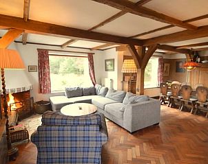 Gezellige woonkamer in Vakantiehuisje in Oploo, Noordoost Brabant, met houten balken en uitzicht op de groene omgeving.