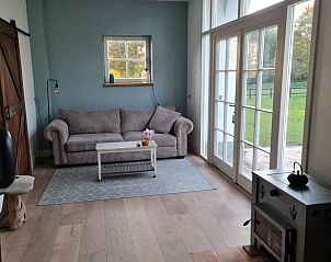 Gezellige woonkamer met uitzicht op tuin in Vakantiehuis in Langenboom, Noordoost Brabant.
