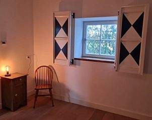 Knusse hoek met houten stoel en raam in Vakantiehuis in Langenboom, Noord Brabant.