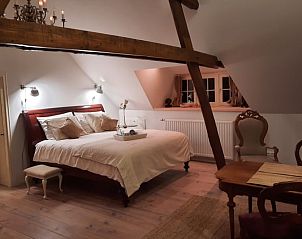 Stijlvolle slaapkamer in Vakantiehuis in Langenboom, Noord Brabant met houten details en sfeervolle verlichting.