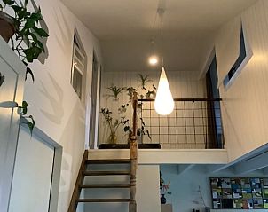 Modern interieur met houten trap in Vakantiehuisje in Escharen, een stijlvol verblijf in Noordoost Brabant.