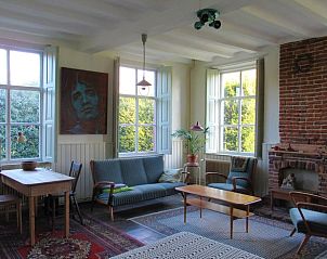 Ruime woonkamer met open haard in Vakantiehuis in Sambeek, Noordoost Brabant.