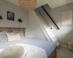 Slaapkamer met trap in Huisje in Beers, vakantiehuis in Beers NB, Noordoost Brabant, met een rustieke uitstraling en gezellige sfeer.