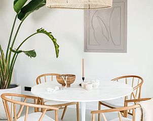 Eettafel in Vakantiehuisje in Beers, Noordoost Brabant, met houten stoelen en een natuurlijke sfeer.