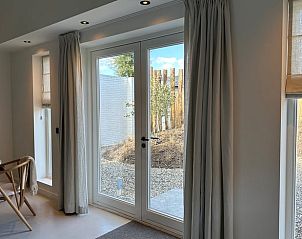 Lichtovergoten binnenruimte in Vakantiehuisje in Beers, Noordoost Brabant met uitzicht op de tuin.