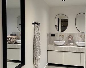 Elegante badkamer in Vakantiehuisje in Beers, Noordoost Brabant met moderne spiegels en wastafels.