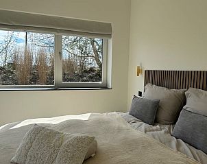 Slaapkamer met uitzicht in Vakantiehuisje in Beers, Noord Brabant, ideaal voor een ontspannen verblijf.