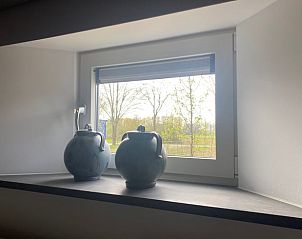 Vensterbank met decoratieve vazen in Huisje in Beers, vakantiehuis in Beers NB, met uitzicht op de tuin.