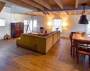 Gezellige woonkamer van Vakantiehuisje in Beugen, Noordoost Brabant, met comfortabele banken en eetruimte.