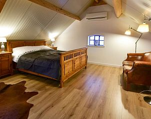 Sfeervolle slaapkamer in Vakantiehuisje in Beugen, Noordoost Brabant, met houten elementen en comfortabele meubels.