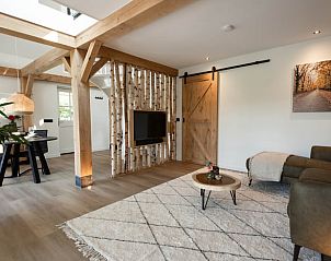 Ruime woonkamer in Vakantiehuis in Reek, Noordoost Brabant, met rustieke houten schuifdeur.