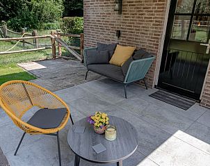 Zithoek op het terras van Vakantiehuis in Reek, Noordoost Brabant, omgeven door groen.