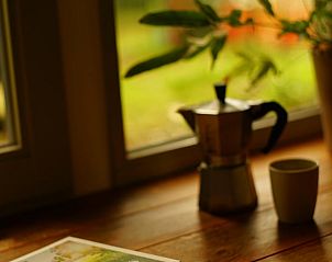 Gezellige hoek in vakantiehuisje in Reek met koffiezetapparaat en uitzicht op de tuin.