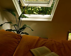 Gezellige slaapruimte in vakantiehuisje in Reek met veel lichtinval en groene omgeving.