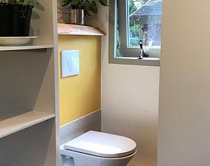 Moderne badkamer in vakantiehuisje in Reek met toilet en wastafel, praktisch en stijlvol.