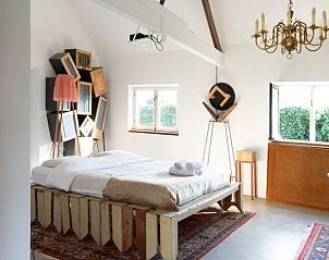 Vakantiehuisje in Huisseling, Noord-Brabant, lichte slaapkamer met uniek decor en comfortabel bed.