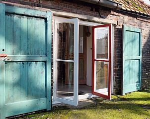 Vakantiehuisje in Huisseling, Noord-Brabant, openstaande deuren naar binnenplaats met mosrijke omgeving.