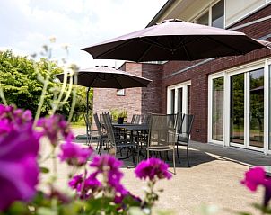 Terras met parasols bij Huisje in Vierlingsbeek, vakantieaccommodatie in Noordoost Brabant, perfect voor ontspannen buiten.