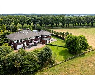 Luchtfoto van Huisje in Vierlingsbeek, een vakantiehuis in Noord Brabant, omgeven door velden en bossen.