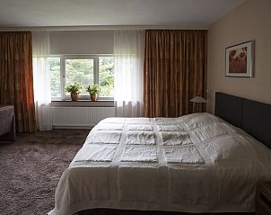 Comfortabele slaapkamer in Huisje in Vierlingsbeek, Noord Brabant, met grote ramen en uitzicht op de tuin.