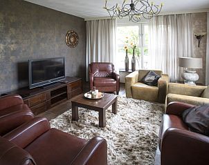 Stijlvolle woonkamer in Huisje in Vierlingsbeek, Noord Brabant, met leren fauteuils en moderne inrichting.