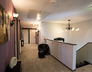 Hal in Huisje in Vierlingsbeek, Noord Brabant, met moderne kunst en sfeervolle verlichting.