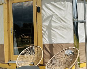 Veranda van Vakantiehuis in Ledeacker met comfortabele stoelen en deur naar binnenruimte.