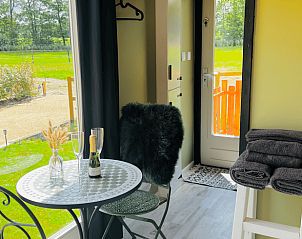 Gezellige binnenruimte van Huisje in Ledeacker, vakantiehuis in Noordoost Brabant, met uitzicht op groene velden en een knus tafeltje.