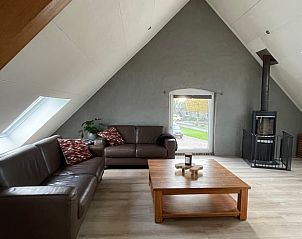 Gezellige woonkamer in Vakantiehuis in Katwijk NB, Noordoost Brabant met comfortabele banken en een houtkachel voor een knusse sfeer.