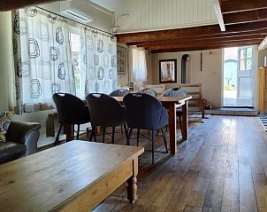 Ruime woonkamer in Vakantiehuisje in Waspik, West Brabant, met houten vloer en comfortabele stoelen.