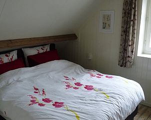 Slaapkamer met comfortabel bed in Vakantiehuisje in Waspik, Noord Brabant, rustieke sfeer.