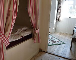 Knusse slaaphoek met gordijnen in Vakantiehuisje in Waspik, Noord Brabant.