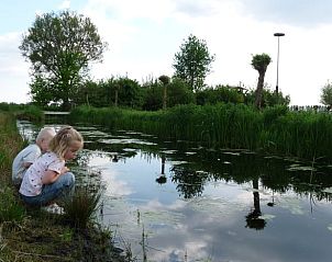 Kinderen verkennen de natuur bij Vakantiehuisje in Waspik, Noord Brabant, langs het water.