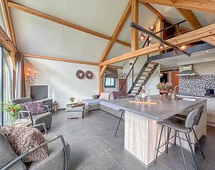 Ruime woonkamer van Villa Brocante in Alphen, vakantiehuis met houten balken en open keuken.