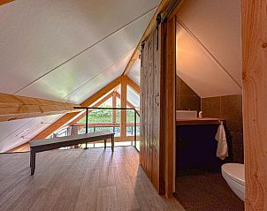 Zolder slaapkamer met houten balken in Villa Brocante, vakantiehuis in Alphen, West Brabant.