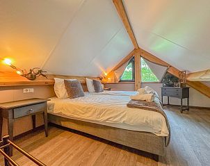 Detail van kussen en lamp in zolder slaapkamer van Villa Brocante, vakantiehuis in Alphen, Noord Brabant.