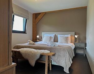 Comfortabele slaapkamer met houten accenten in Villa Bianco, Alphen.