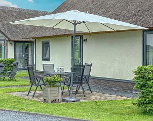 Zonnig terras met parasol bij Villa Bianco vakantiehuis, Alphen, Noord Brabant.
