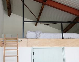 Slaapzolder in Vakantiehuisje in Gilze, West Brabant, met houten ladder.