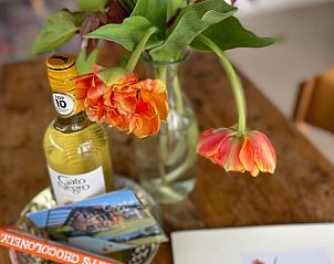 Gezellige binnenruimte van Vakantiehuis in Gilze met bloemen en lokale lekkernijen, gelegen in West Brabant.