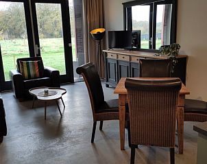 Cozy living room of Huisje in Rucphen, vacation home in West Brabant, overlooking green nature from the spacious indoor area.
