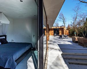 Slaapkamer en terras in Vakantiehuisje in Oosterhout, Noord Brabant, met moderne stijl.