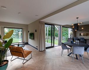 Stilvolles Wohnzimmer des Ferienhauses in Oosterhout mit Blick auf den grnen Garten in Nordbrabant.